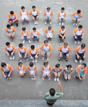 The drillmaster gives fit-keeping class to the children in the weight-reducing summer camp held in Changsha, capital of central China