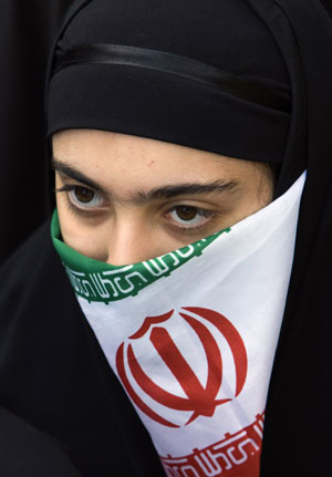 An Iranian student covers her face with an Iranian flag during a rally outside the former U.S. embassy in Tehran November 4, 2009.(Xinhua/Reuters Photo)