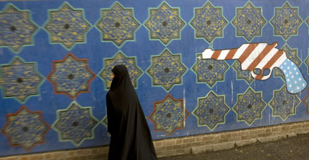 An Iranian walks past a mural outside the former U.S. embassy in Tehran November 4, 2009. (Xinhua/Reuters Photo)