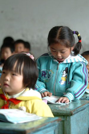 A little pupil stands up to elocnte the text at the Jinzhai County's Hope Primary School, in Jinzhai, east China's Anhui Province, Oct. 27, 2009. China's first Hope Primary School, the Jinzhai County's Hope Primary School, which is symbolic of the formal inception of China's Project Hope aimed at helping dropouts return to schools, was set up in Nanxi Town, Jinzhai County, east China's Anhui Province on May 19, 1990. As the very first beneficiary of Project Hope, the largest charitable organization for education, the Jinzhai Primary School has gained extensive support and substantial helps from all walks of life in the society during its past 19 years, and its teaching ambience and peripheral equipments have been remarkably improved. The Hope Primary School now covers some 14,200 square meters, boasts 21 classes consisting of 53 teachers and 1,410 students. (Xinhua/Liu Junxi)