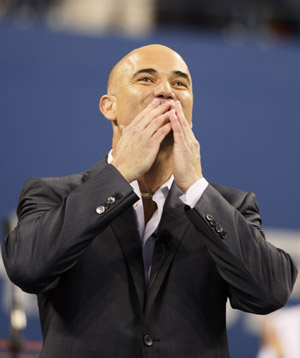 Former tennis champion Andre Agassi salutes the crowd during the opening ceremony at the U.S. Open tennis tournament in New York, August 31, 2009.