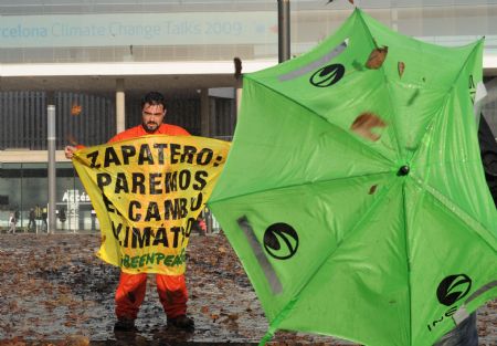 A Greenpeace activist displays a banner during a demonstration outside the venue of the UN 2009 5th Climate Change Talks in Barcelona, Spain, Nov. 5, 2009.[Xinhua]