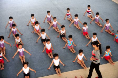 Yang Le, a 6-year-old girl, and her little teammates practise free exercise in a gymnastics school of Xiantao, city of central China's Hubei Province, on Oct. 15, 2009.(Xinhua/Li Xiaoguo)