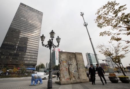 Office workers walk past a section of the Berlin Wall displayed at Berlin Plaza in central Seoul November 5, 2009.(Xinhua/Reuters Photo)