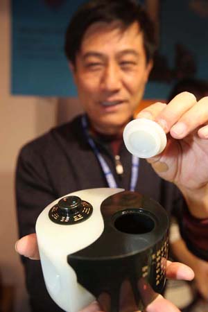 A staff worker shows a jade pot on a jewelry exhibition held at China International Exhibition Center in Beijing, China, Nov. 5, 2009. The 5-day-long 2009 China International Jewelry Exhibition kicked off here on Thursday with about 600 companies from 15 countries and regions on shown. (Xinhua)