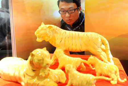 A visitor views gold exhibits on a jewelry exhibition held at China International Exhibition Center in Beijing, China, Nov. 5, 2009. The 5-day-long 2009 China International Jewelry Exhibition kicked off here on Thursday with about 600 companies from 15 countries and regions on shown. (Xinhua)