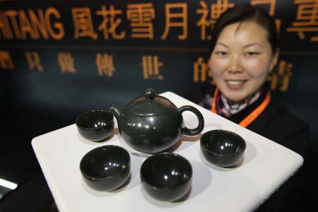 A staff worker shows a jade tea set on a jewelry exhibition held at China International Exhibition Center in Beijing, China, Nov. 5, 2009. The 5-day-long 2009 China International Jewelry Exhibition kicked off here on Thursday with about 600 companies from 15 countries and regions on shown. (Xinhua) 