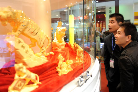 Visitors view gold exhibits on a jewelry exhibition held at China International Exhibition Center in Beijing, China, Nov. 5, 2009. The 5-day-long 2009 China International Jewelry Exhibition kicked off here on Thursday with about 600 companies from 15 countries and regions on shown. (Xinhua)