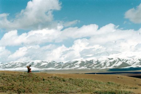 A Tibetan woman takes her child to school sponsored by Hope Project from Layihai village, Daotanghe town, Gonghe County, northwest China's Qinghai Province, in April 1999. Over 90% children in this village go to school since the boarding school was built in 1990's.(Xinhua Photo)