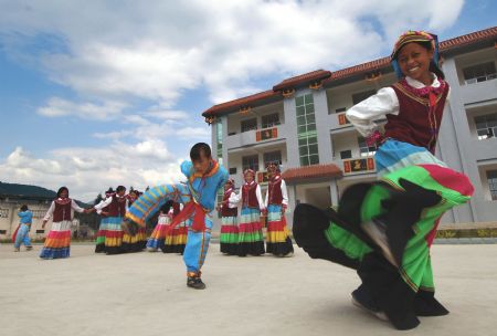 Students of Yi nationality dance at a local Hope Primary School in Mianning County, southwest China's Sichuan Province, June 20, 2006.(Xinhua Photo)