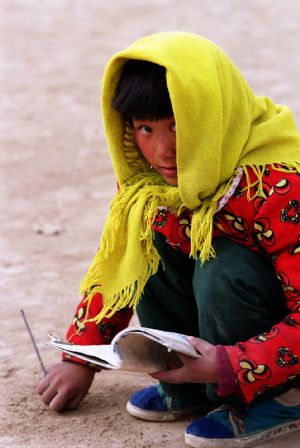 A girl practices writing with a stick on the ground at a primary school in Wanyaozi village, Lintao County, northwest China's Gansu Province, in December, 1998. Many children in this village went back to school with the help of Hope Project.(Xinhua Photo)