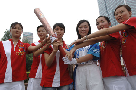 Su Mingjuan (3rd L), whose portrait was regarded as the public image of Hope Project, displays the torch of 2008 Beijing Olympics during a torchbearer selective trial in Hefei, capial of east China's Anhui Province, July 7, 2007.(Xinhua Photo)