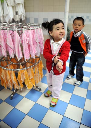 Song Xinyi (L) smiles in her kindergarten in Chengdu, capital city of southwest China's Sichuan Province, on Oct. 26, 2009. 