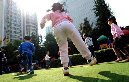 Song Xinyi (C) runs with other children in her kindergarten in Chengdu, capital city of southwest China's Sichuan Province, on Oct. 27, 2009.