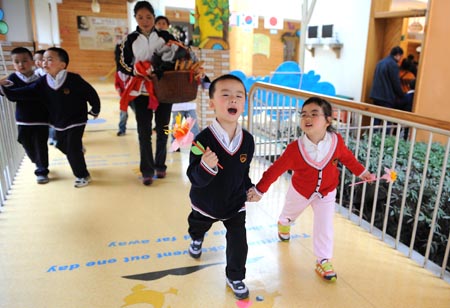  Song Xinyi (R) walks hand in hand with a boy in kindergarten in Chengdu, capital city of southwest China's Sichuan Province, on Oct. 26, 2009.