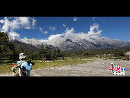 Soaring to 5500m, some 35km from Lijiang, is Yulong Xueshan, also known as Mt Satseto. In Lijiang City you can have a magnificent view of Jade Dragon Snow Mountain, with the main peak thrust into the clouds, the Old Man Peak standing out on the right and Black Snow Peak on its left. The 13 peaks of 18,360-foot Jade Dragon Snow Mountain, a treasure of wild plants and rare animals, are like a silver dragon lying in the clouds. Awesome and unconquered, they dominate the Lijiang Plain. [Photo by Sarah] 