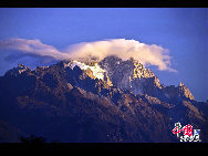 Soaring to 5500m, some 35km from Lijiang, is Yulong Xueshan, also known as Mt Satseto. In Lijiang City you can have a magnificent view of Jade Dragon Snow Mountain, with the main peak thrust into the clouds, the Old Man Peak standing out on the right and Black Snow Peak on its left. The 13 peaks of 18,360-foot Jade Dragon Snow Mountain, a treasure of wild plants and rare animals, are like a silver dragon lying in the clouds. Awesome and unconquered, they dominate the Lijiang Plain. [[Photo by Sarah]  