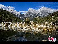 Soaring to 5500m, some 35km from Lijiang, is Yulong Xueshan, also known as Mt Satseto. In Lijiang City you can have a magnificent view of Jade Dragon Snow Mountain, with the main peak thrust into the clouds, the Old Man Peak standing out on the right and Black Snow Peak on its left. The 13 peaks of 18,360-foot Jade Dragon Snow Mountain, a treasure of wild plants and rare animals, are like a silver dragon lying in the clouds. Awesome and unconquered, they dominate the Lijiang Plain. [[Photo by Sarah] 