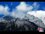 Soaring to 5500m, some 35km from Lijiang, is Yulong Xueshan, also known as Mt Satseto. In Lijiang City you can have a magnificent view of Jade Dragon Snow Mountain, with the main peak thrust into the clouds, the Old Man Peak standing out on the right and Black Snow Peak on its left. The 13 peaks of 18,360-foot Jade Dragon Snow Mountain, a treasure of wild plants and rare animals, are like a silver dragon lying in the clouds. Awesome and unconquered, they dominate the Lijiang Plain. [[Photo by Sarah] 