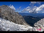 Soaring to 5500m, some 35km from Lijiang, is Yulong Xueshan, also known as Mt Satseto. In Lijiang City you can have a magnificent view of Jade Dragon Snow Mountain, with the main peak thrust into the clouds, the Old Man Peak standing out on the right and Black Snow Peak on its left. The 13 peaks of 18,360-foot Jade Dragon Snow Mountain, a treasure of wild plants and rare animals, are like a silver dragon lying in the clouds. Awesome and unconquered, they dominate the Lijiang Plain. [Photo by Sarah] 