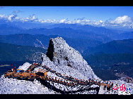 Soaring to 5500m, some 35km from Lijiang, is Yulong Xueshan, also known as Mt Satseto. In Lijiang City you can have a magnificent view of Jade Dragon Snow Mountain, with the main peak thrust into the clouds, the Old Man Peak standing out on the right and Black Snow Peak on its left. The 13 peaks of 18,360-foot Jade Dragon Snow Mountain, a treasure of wild plants and rare animals, are like a silver dragon lying in the clouds. Awesome and unconquered, they dominate the Lijiang Plain. [Photo by Sarah] 