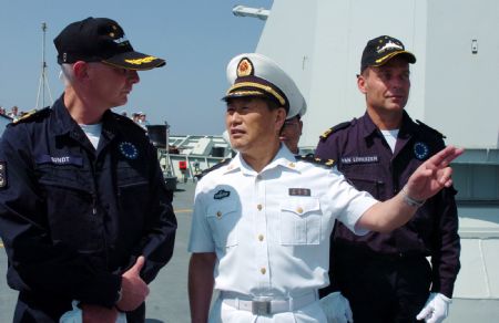 Wang Zhiguo (R front), commander of the Chinese naval 3rd escort fleet, speaks to Pieter Bindt (L), commander of the European Union (EU) navy 465 formation, during the latter's visit to the Chinese 'Zhoushan' Warship at Wang's invitation at the Gulf of Aden Nov. 8, 2009. [Guo Gang/Xinhua]