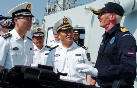 Wang Zhiguo (front C), commander of the Chinese naval 3rd escort fleet, looks on as Pieter Bindt (R), commander of the European Union (EU) navy 465 formation, speaks during Pieter Bindt's visit to the Chinese 'Zhoushan' Warship at Wang's invitation at the Gulf of Aden Nov. 8, 2009. [Guo Gang/Xinhua] 