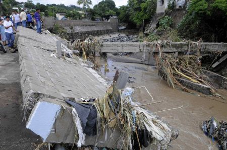 Salvadorans looks at the damaged roads caused by heavy rains in San Salvador November 8, 2009. The death toll in El Salvador from the rains and flooding provoked in the last hours by hurricane Ida rose on Sunday to 91. [Xinhua/Reuters]