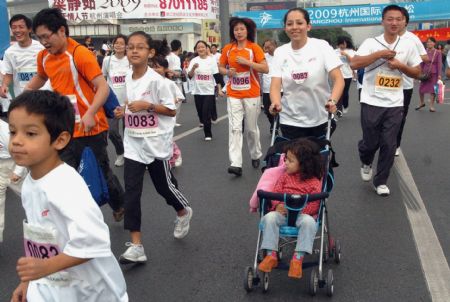 A foreign woman and her child take part in the 'family run' activity of the 2009 Hangzhou International Marathon in Hangzhou, capital of east China's Zhejiang Province, Nov. 8, 2009.[Xinhua]