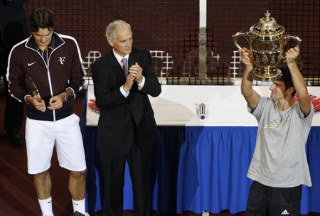 Serbia's Novak Djokovic (R) celebrates with his trophy after his victory against Switzerland's Roger Federer (L) in their final match at the Swiss Indoors ATP tennis tournament in Basel November 8, 2009. [Xinhua/Reuters]