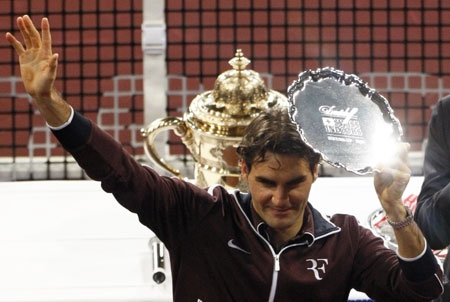 Switzerland's Roger Federer holds his trophy after he was defeated by Serbia's Novak Djokovic in their final match at the Swiss Indoors ATP tennis tournament in Basel November 8, 2009.[Xinhua/Reuters]