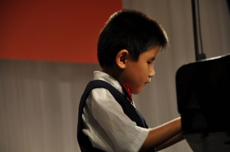 Liu Hao, an eight-year-old blind boy of a worker's family, plays piano during the shooting of a film narrating the story of his own, in Chifeng City, north China's Inner Mongolia Autonomous Region, Jan. 5, 2008. [Xinhua]