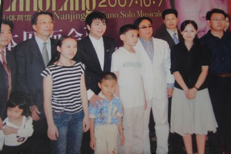 Photo taken on Oct. 7, 2007 shows Liu Hao, an eight-year-old blind boy of a worker's family in Chifeng City, north China's Inner Mongolia Autonomous Region, posing for a group photo with Lang Lang and other musical celebrities. [Xinhua]