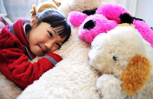 Photo taken on Nov. 1, 2009 shows Zhang Mingyang and her dog dolls at home in Harbin, capital of northeast China's Heilongjiang province. [Xinhua]