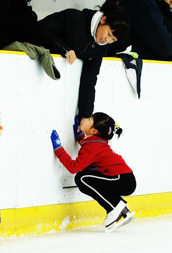 Zhang Mingyang (Bottom) talks with her mother Zhang Liting during her rest in morning exercise in Harbin, capital of northeast China's Heilongjiang province, Nov, 1, 2009. [Xinhua]