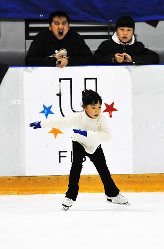 Zhang Mingyang skates as her parents watch in the ice stadium in Harbin, capital of northeast China's Heilongjiang province, Nov. 2, 2009. Her father Zhang Tianling yawns because it's too early in the morning.[Xinhua] 