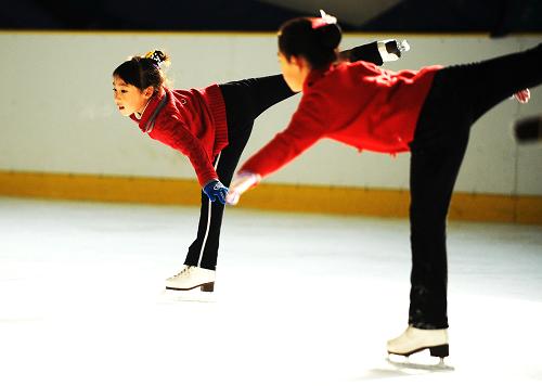  Zhang Mingyang (L) skates during morning exercises in Harbin, capital of northeast China's Heilongjiang province, Nov. 1, 2009. [Xinhua]