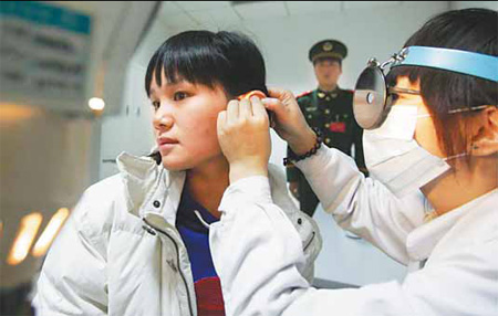 A young woman has a medical exam at Daxing District Hospital yesterday as part of the Autumn army recruitment.
