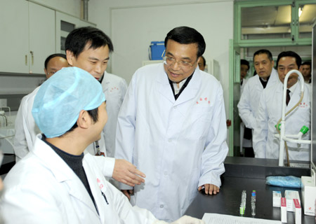 Chinese Vice Premier Li Keqiang (C) gets to know the examining conditions of A/H1N1 flu vaccine during an inspection of the National Institute for the Control of Pharmaceutical and Biological Products in Beijing, capital of China, on Nov. 9, 2009. Li Keqiang inspected here on Monday, which further highlighted the government's resolve to carry on the influenza vaccination campaign amid the growing infections. [Ma Zhancheng/Xinhua]