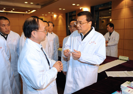 Chinese Vice Premier Li Keqiang (1st R, front) gets to know the production and price of A/H1N1 flu vaccine during an inspection of the National Institute for the Control of Pharmaceutical and Biological Products in Beijing, capital of China, on Nov. 9, 2009. [Ma Zhancheng/Xinhua] 