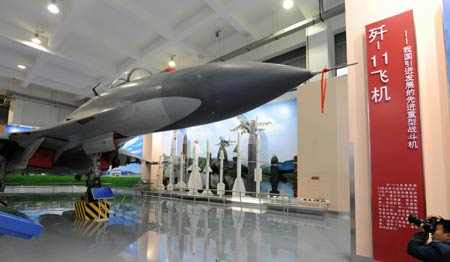 A visitor takes pictures for a jet fighter displayed at China Aviation Museum in Beijing, capital of China, Nov. 9, 2009. To celebrate the 60 anniversary of the founding of the Air Force of the Chinese People's Liberation Army, an exhibition displaying the achievements of the development of the weapons and equipments of the Air Force of the Chinese People's Liberation Army will be open to the public from Nov. 15 in Beijing. [Xinhua]
