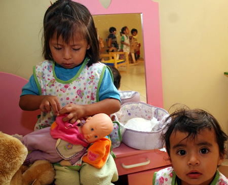 Kids play with a doll at the kindergarten of a women's prison in Quito, Ecuador, Nov. 6, 2009. [Hao Yunfu/Xinhua]