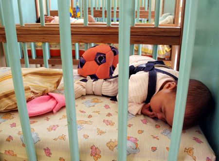 A kid takes a sleep at the kindergarten of a women's prison in Quito, Ecuador, Nov. 6, 2009. [Hao Yunfu/Xinhua] 