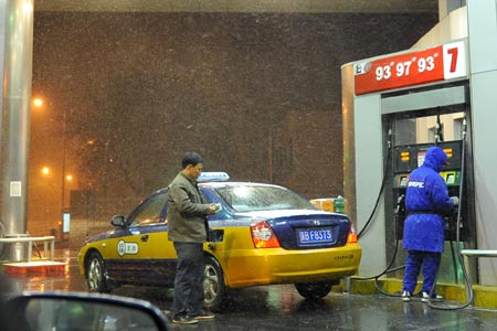 A taxi driver refuels his car at a gas station in Beijing, capital of China, late Nov. 9, 2009.
