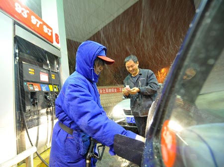 A worker refuels a taxi at a gas station in Beijing, capital of China, late Nov. 9, 2009. 