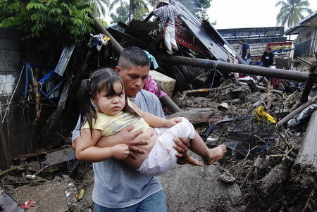 A man carries a girl on a street damaged by heavy rains in Verapaz, about 71 km (44 miles) east to San Salvador November 8, 2009. Hurricane Ida roared into the Gulf of Mexico on Sunday, where important oil fields are located, after killing 91 people and leaving at least another 60 missing in floods and mudslides in El Salvador. [Agencies] 