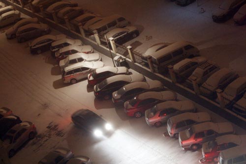 Snow-capped vehicles are seen at a residential community in east Beijing early on Tuesday morning, November 10, 2009. Heavy snow hit the capital on Monday night. Meteorological departments forecast that the snowy weather will last about four days. [Photo: Beijing Morning Post/CFP] 