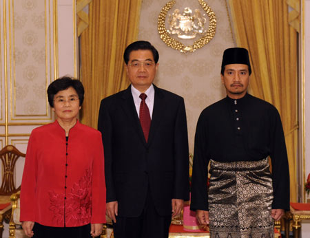 Chinese President Hu Jintao (C) and his wife Liu Yongqing pose with Malaysian Supreme Head of State Mizan Abidin (R) for a group photo during their meeting in Kuala Lumpur, Malaysia, Nov. 10, 2009. [Xinhua]