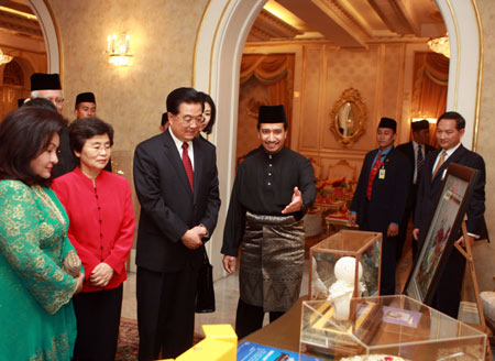 Chinese President Hu Jintao (3rd L, front) exchanges gifts with Malaysian Supreme Head of State Mizan Abidin (4th L, front) after their meeting in Kuala Lumpur, Malaysia, Nov. 10, 2009. [Xinhua]