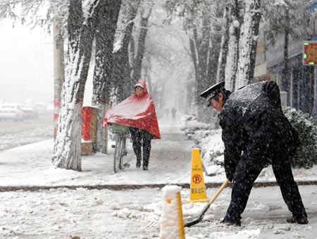 A man clears snow in Taiyuan, capital of north China's Shanxi Province, Nov. 10, 2009. Most parts in north and northwest China witnessed a snowfall on Tuesday. [Xinhua]